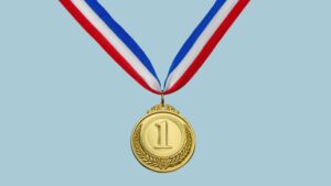 A gold medal with a number one on it hangs from a red, white, and blue ribbon against a blue background